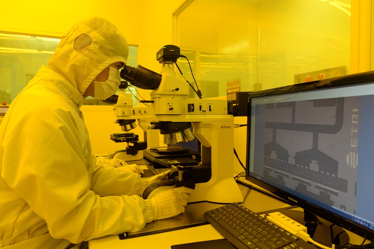 ETRI 연구진이 광학현미경으로 질화갈륨 집적회로를 점검하고 있다