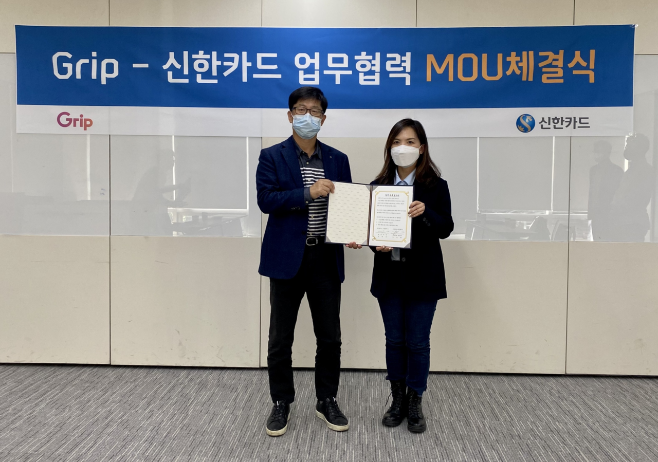 김정배 신한카드 파트너십 본부장(왼쪽)과  김한나 그립컴퍼니 대표(오른쪽)가 협약서를 들고 기념 촬영을 하고 있다. 