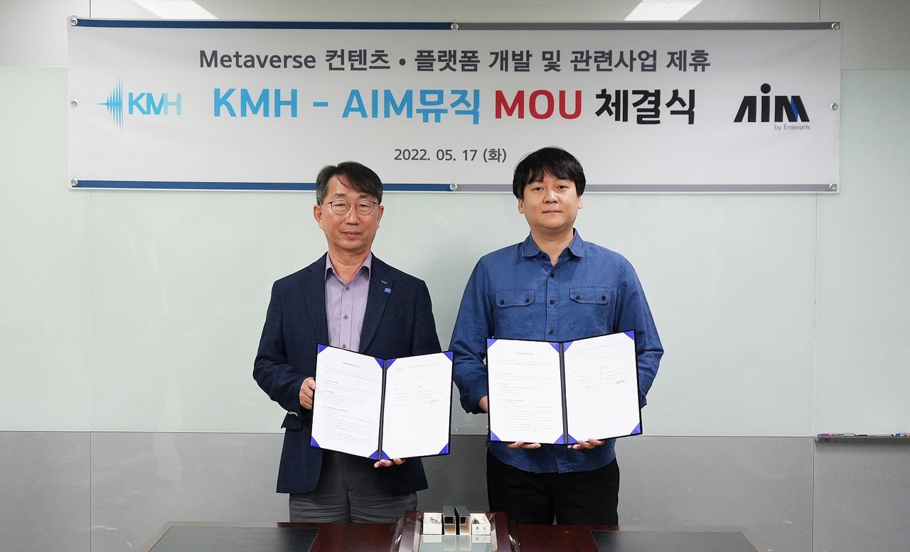 5월 17일 서울 양천구 목동 KMH 회의실에서 한찬수KMH대표이사(왼쪽)와 박찬재 AIM뮤직 대표이사(오른쪽)가 업무협약서를 펼쳐 보이고 있다.