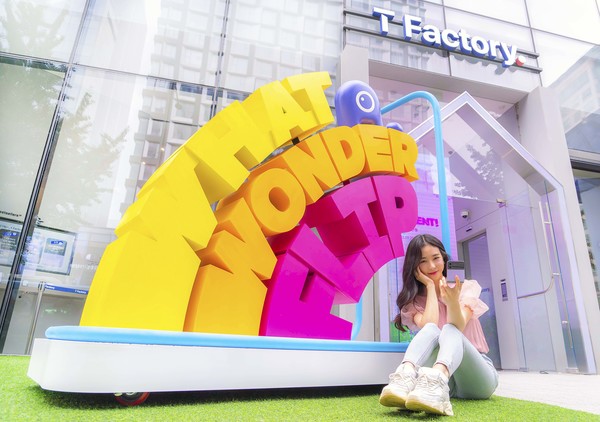 SK텔레콤 홍보모델이 홍대 ICT멀티플렉스 T팩토리에 설치된 원더플립 체험존을 소개하고 있다. [사진=SKT]