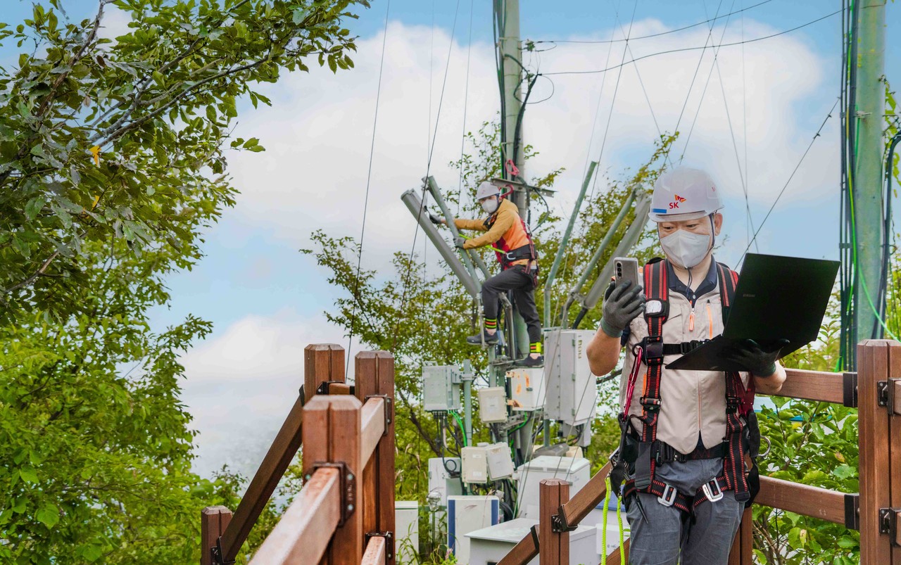SK텔레콤이 온실가스 배출을 줄이고 넷제로(Net Zero)를 실현하기 위해 친환경 인프라 기술의 집중 육성에 나선다. 사진은 SK텔레콤 자회사 SK오엔에스 엔지니어들이 경기 파주시 산악지역에 설치된 중계기 장비를 점검하는 모습 [사진=SK텔레콤]
