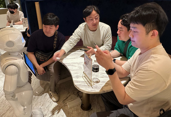 프로그램에 참여한 직원들이 일본 도쿄의 PEPPER PARLOR 카페에서 서비스 로봇 이용을 체험하고 있는 모습. [사진=LG유플러스]