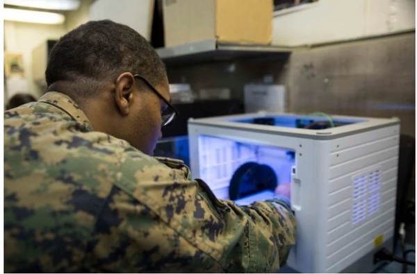 미 해병대원이 3D 프린팅 기기에서 보급품 출력이 가능한지를 시험하고 있다. [사진=미해병대 사령부]