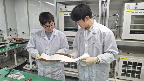 ETRI 연구진이 롤 형태로 제조된 대면적 고체전해질막의 전체 품질과 외관 상태를 육안으로 점검하는 모습 [제공=ETRI]